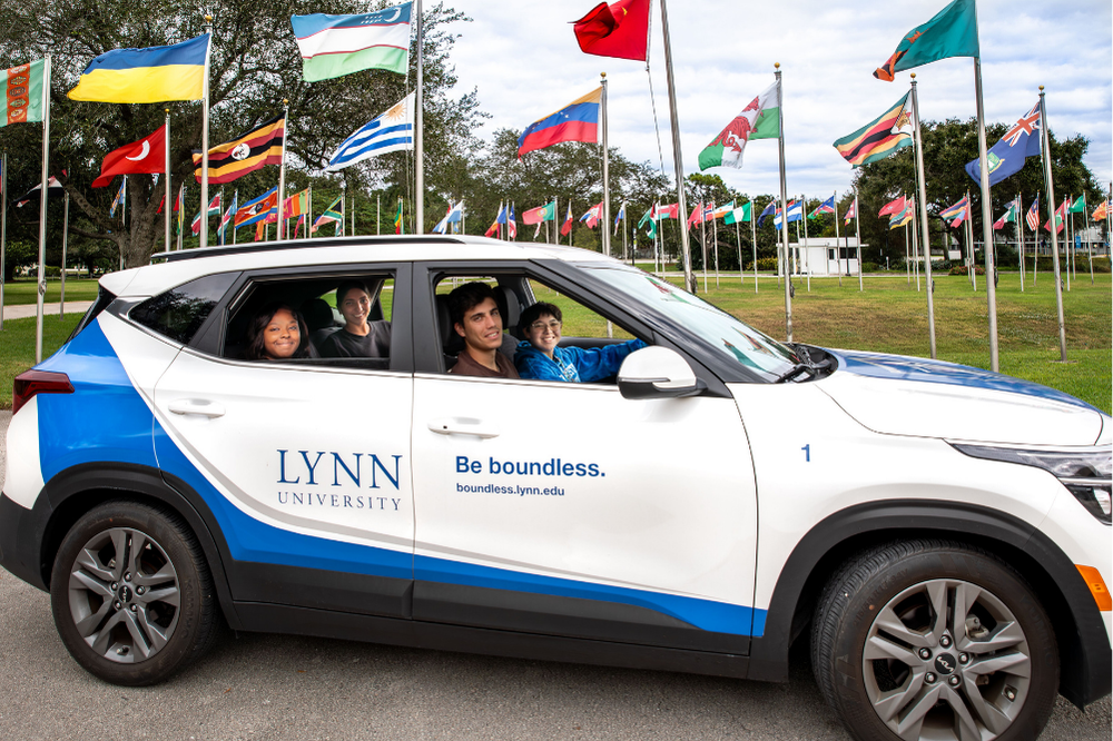 Students in Lynn Kia driving around the Circle of Flags
